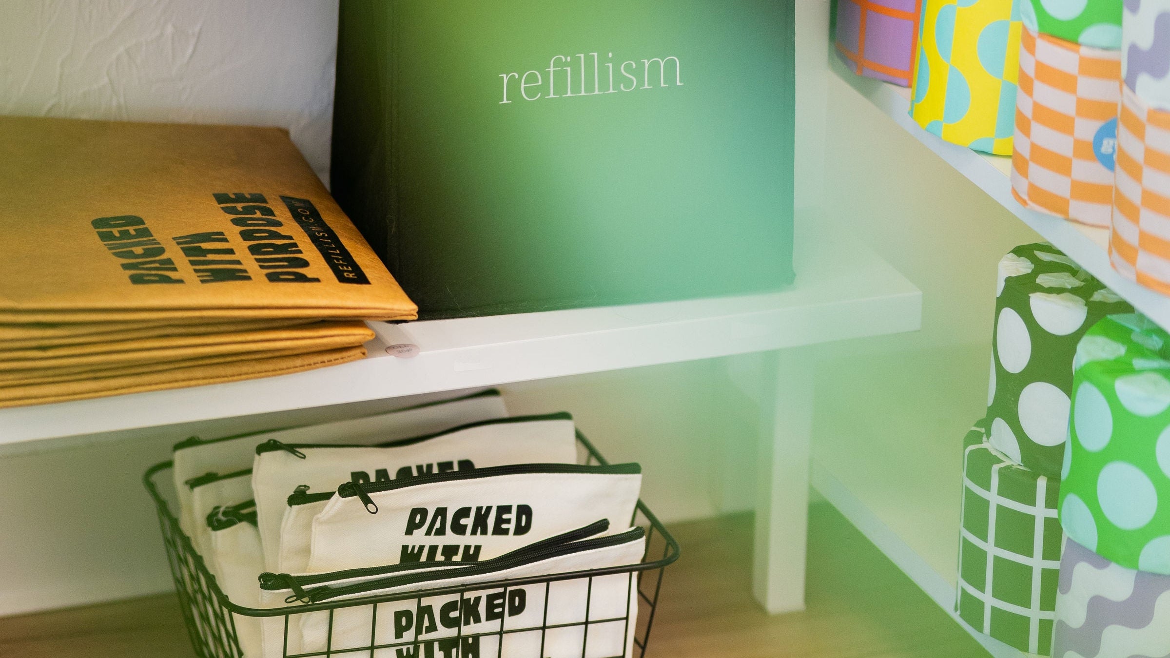 Shelving unit with colorful notebooks and stationery items on a wooden floor.